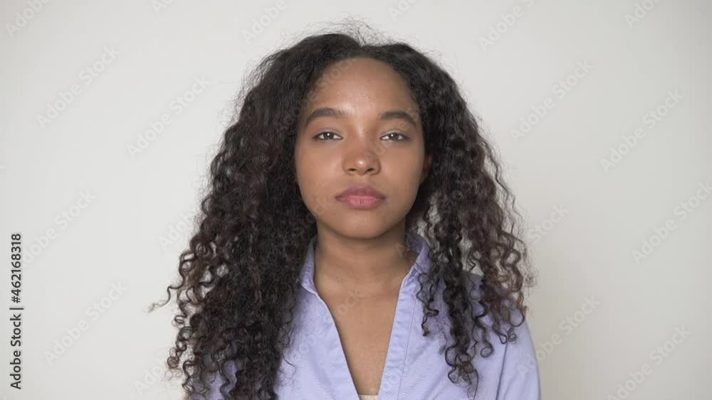 Model shooting in studio. Epspb Portrait of pretty African-American teenage girl wearing purple shirt posing for camera on light grey background closeup Model shooting in studio. Epspb Portrait of pretty African-American teenage girl wearing purple shirt posing for camera on light grey background closeup
