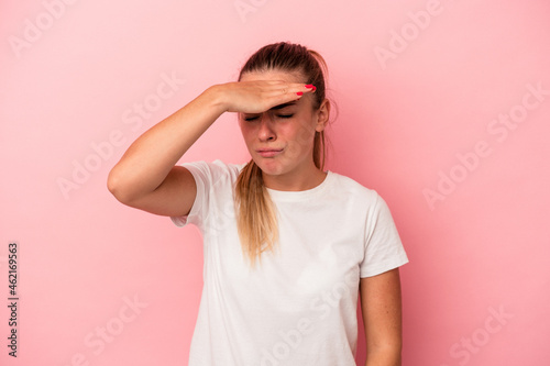 Young Russian woman isolated on pink background touching temples and having headache.