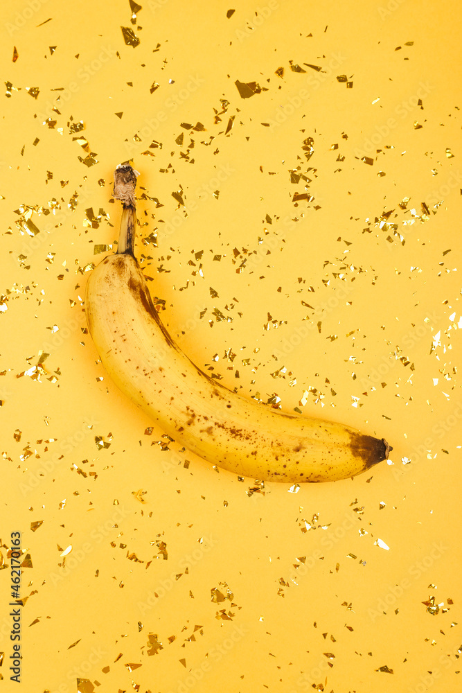 Over ripe banana on a yellow background.
