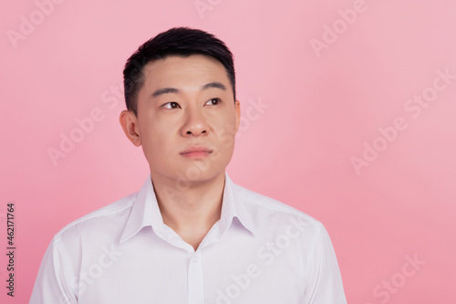 Photo of curious dreamy thoughtful korean man look empty space isolated pink color background © Tetiana