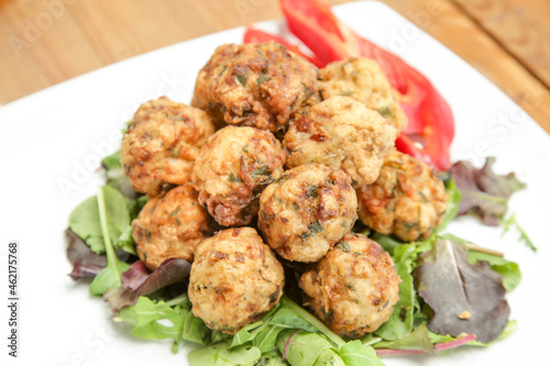 Meatballs served on a plate with green salad
