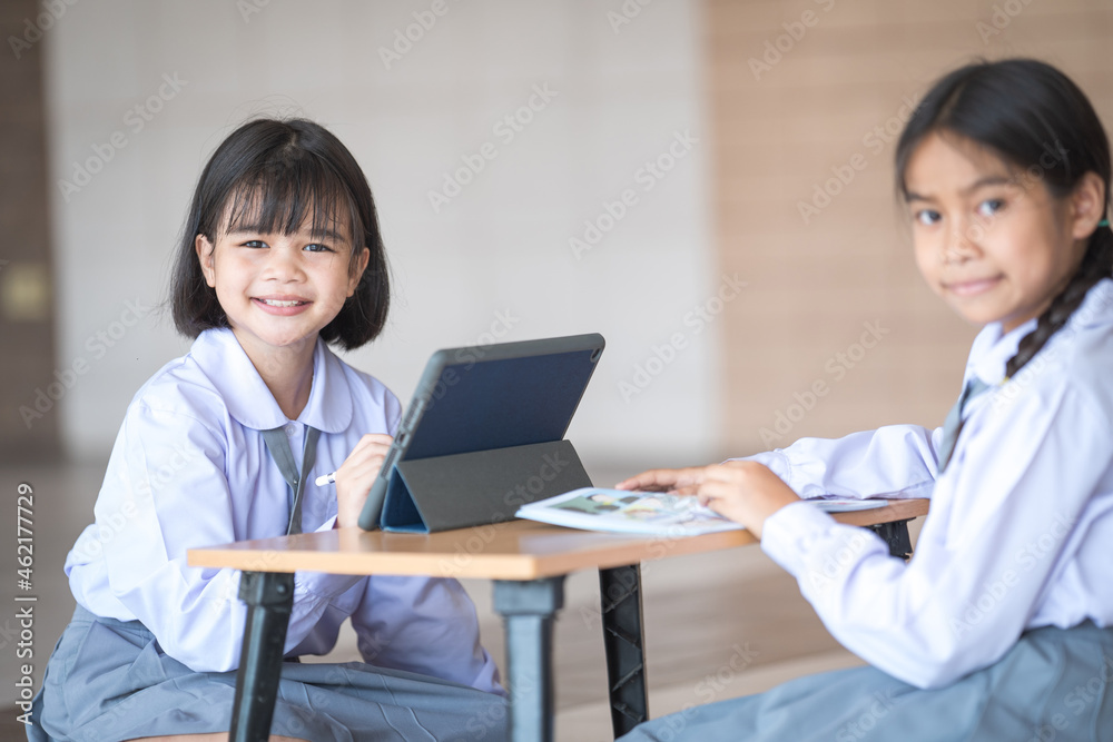 Asian children student friends back to school and study together using digital tablet and write on notebook at school afet Covid-19 lockdown. Back to School Concept Stock Photo Asian children student friends back to school and study together using digital tablet and write on notebook at school afet Covid-19 lockdown. Back to School Concept Stock Photo