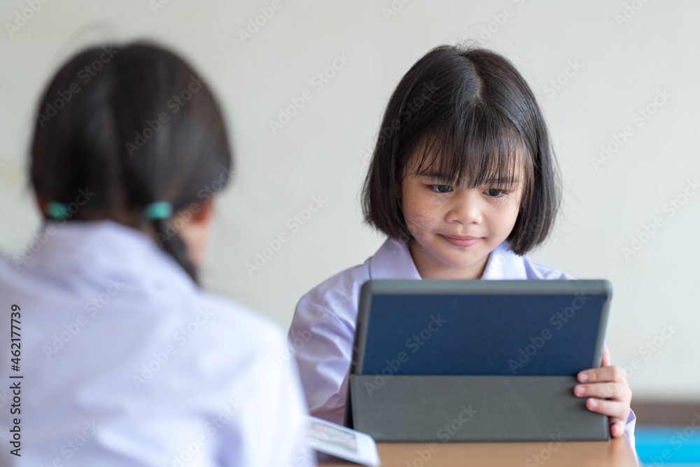 Asian children student friends back to school and study together using digital tablet and write on notebook at school afet Covid-19 lockdown. Back to School Concept Stock Photo Asian children student friends back to school and study together using digital tablet and write on notebook at school afet Covid-19 lockdown. Back to School Concept Stock Photo