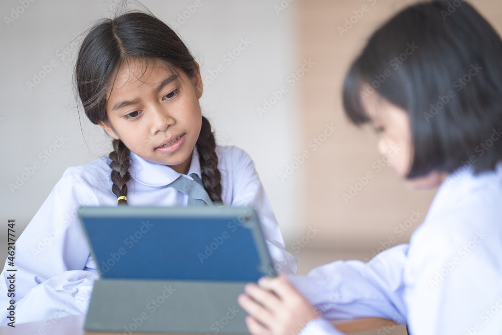 Asian children student friends back to school and study together using digital tablet and write on notebook at school afet Covid-19 lockdown. Back to School Concept Stock Photo Asian children student friends back to school and study together using digital tablet and write on notebook at school afet Covid-19 lockdown. Back to School Concept Stock Photo