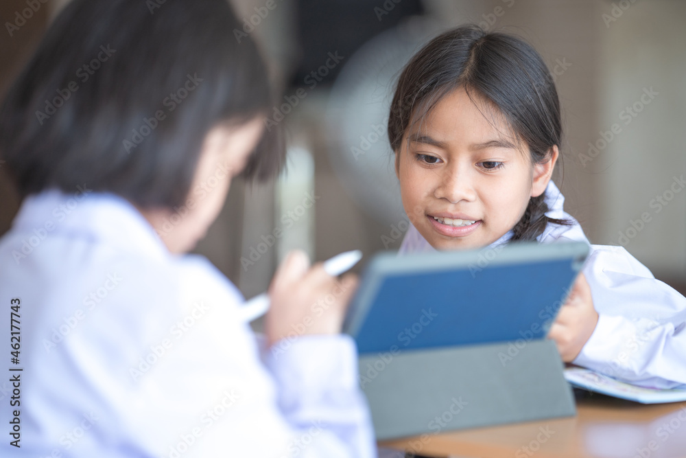 Asian children student friends back to school and study together using digital tablet and write on notebook at school afet Covid-19 lockdown. Back to School Concept Stock Photo Asian children student friends back to school and study together using digital tablet and write on notebook at school afet Covid-19 lockdown. Back to School Concept Stock Photo