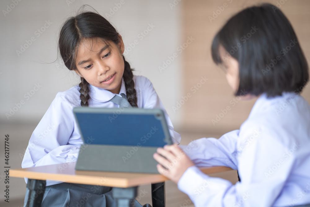 Asian children student friends back to school and study together using digital tablet and write on notebook at school afet Covid-19 lockdown. Back to School Concept Stock Photo Asian children student friends back to school and study together using digital tablet and write on notebook at school afet Covid-19 lockdown. Back to School Concept Stock Photo