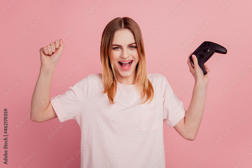 Photo of young woman rejoice success victory console video game free-time isolated on pink color background Photo of young woman rejoice success victory console video game free-time isolated on pink color background