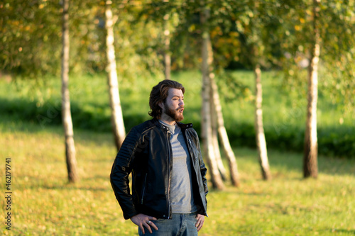 Young bearded man standing and singing song against a background of colorful autumn trees