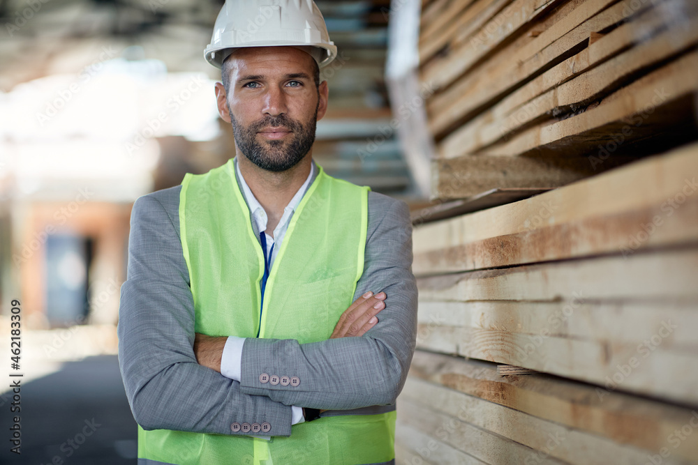 Confident warehouse manager with arms crossed looks at camera. Confident warehouse manager with arms crossed looks at camera.