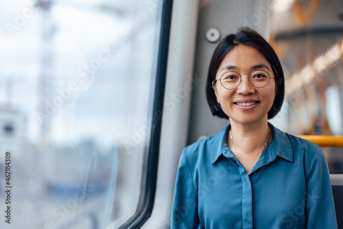 Portrait of a smiling Asian woman in European public transport.