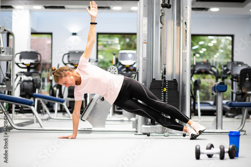 fit young woman in sportswear trainings in a gym healthy active lifestyle