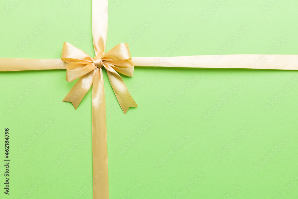 Top view of gold ribbon rolled and yellowbow isolated on colored background. Flat lay with copy space Top view of gold ribbon rolled and yellowbow isolated on colored background. Flat lay with copy space