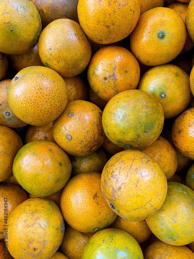The oranges are piled on the shelves that are sold in the market