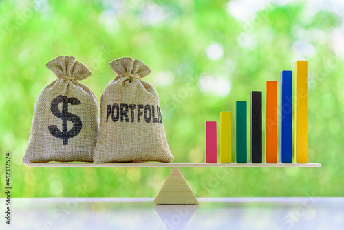 Diversification return and leveraged portfolio concept : Dollar and portfolio bags, rising bar graph on basic balance scale, depicts balancing between investment asset and long-term sustainable growth photo