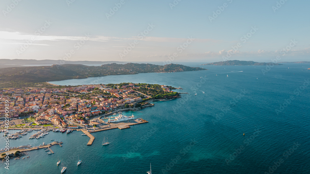Sunset at the coastal village of Palau in northern sardinia. perfect for vacation, clear blue water. Boats and yachts anchored on the jetty. the ferry sets sail towards the island of La Maddalena