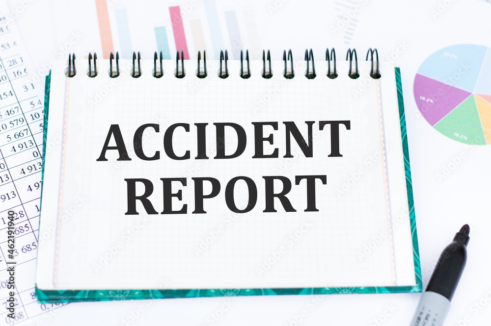Business and finance. On the table are reports, charts, a notebook with the inscription - Accident report Business and finance. On the table are reports, charts, a notebook with the inscription - Accident report