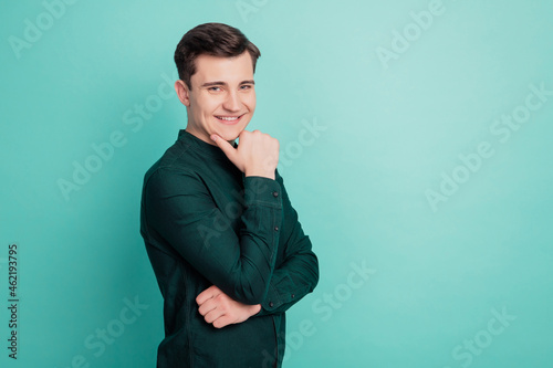 Portrait of minded brainy young business man thinking isolated over teal background © Tetiana