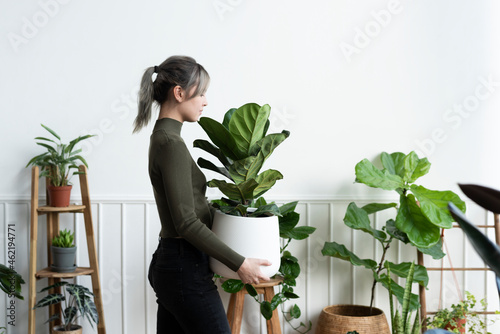 Εκτύπωση καμβά Happy woman carrying a houseplant