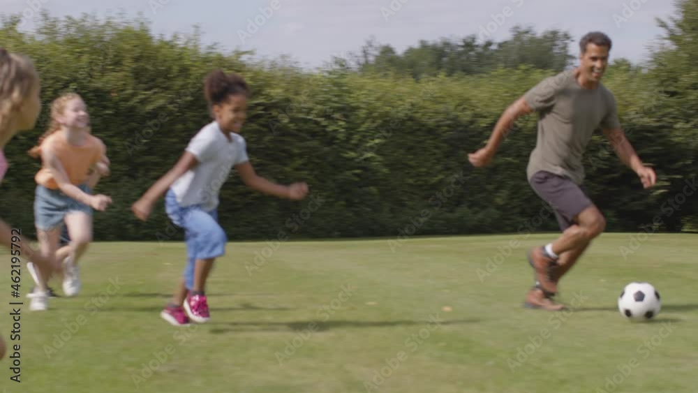 Tracking Shot of Adult Playing Football with Group of Children 01 Tracking Shot of Adult Playing Football with Group of Children 01