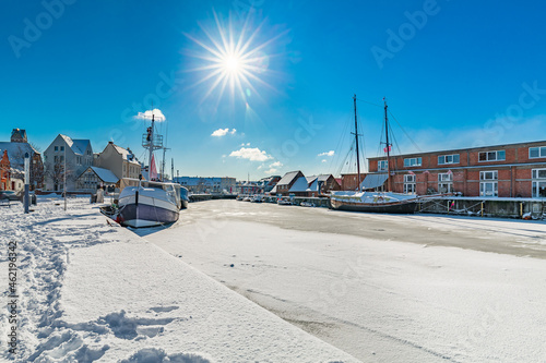 View of Wismar Old harbor in winter, with ships, houses and snow, Germany