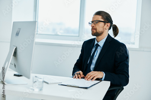 male manager sitting at a desk in front of a computer executive