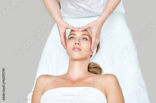 Face massage at spa salon. Doctor hands. Closeup view. High quality photo. Pretty female patient. Beauty treatment. Healthy skin procedure. Young woman head. Light background. Scrub rejuvenation