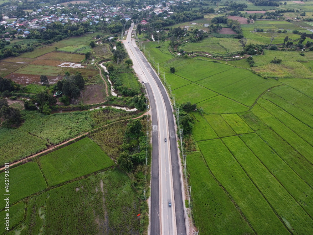 An aerial photograph of a road under construction in a green field.
