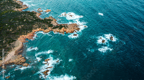  Island coastline with powerful waves breaks on the rocks, early in the morning. Aerial view over the mediterane ocean water at the steep cliffs. Drone shot Italy
