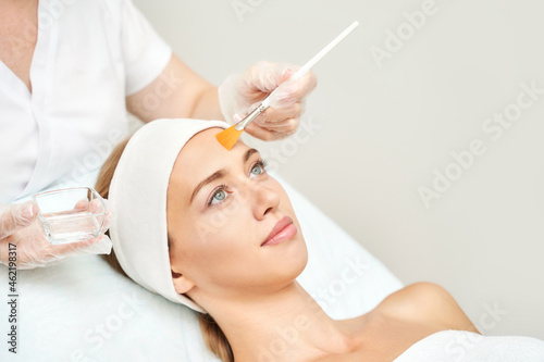 Cosmetology beauty procedure. Young woman skin care. Beautiful female person. Rejuvenation treatment. Facial chemical peel therapy. Clinical healthcare. Doctor hand. Dermatology cleanser. photo