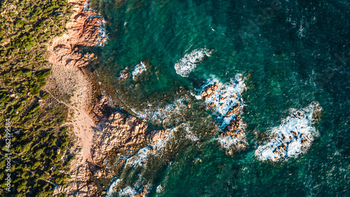 Island coastline with powerful waves breaks on the rocks  early in the morning. Aerial view over the mediterane ocean water at the steep cliffs. Drone shot Italy