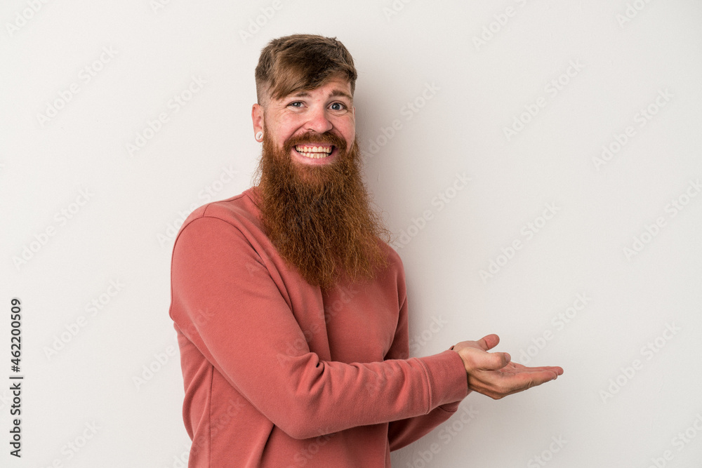 Young caucasian ginger man with long beard isolated on white background holding a copy space on a palm. Young caucasian ginger man with long beard isolated on white background holding a copy space on a palm.