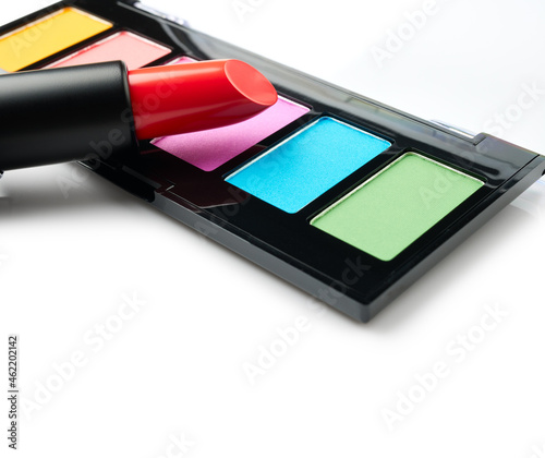 Eye shadow palette and red lipstick isolated on white background close up