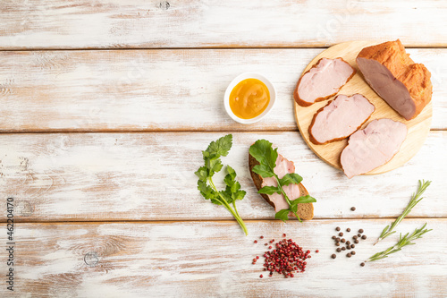 Smoked pork ham on cutting board on white wooden background. Top view, copy space.