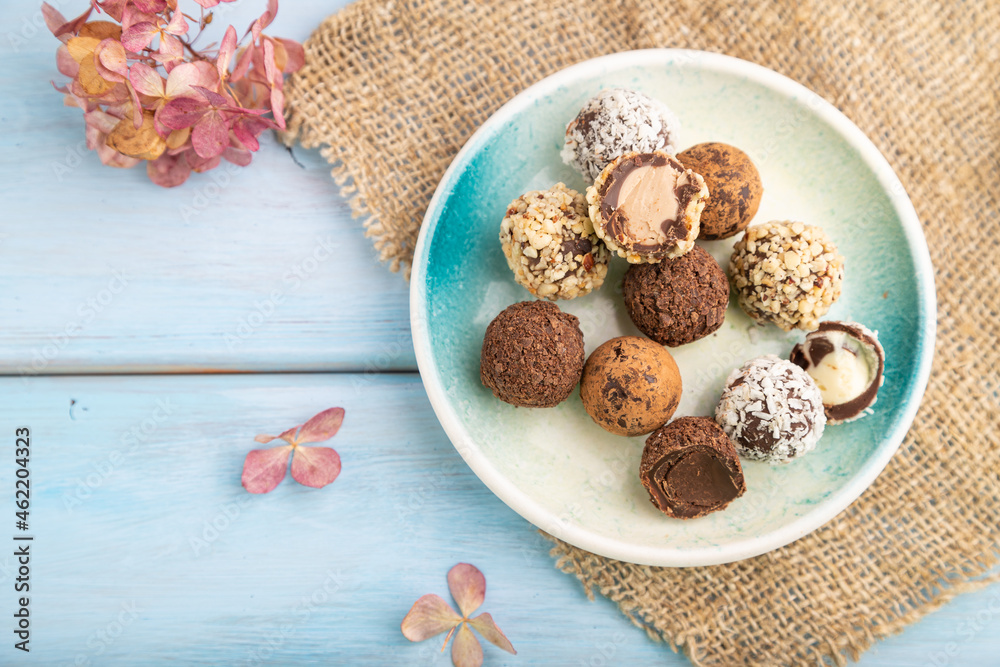 Chocolate truffle candies with cup of coffee on a blue wooden background. top view, close up. Chocolate truffle candies with cup of coffee on a blue wooden background. top view, close up.