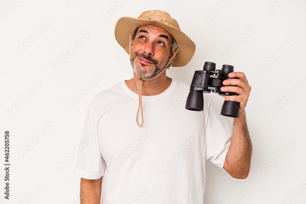Middle age caucasian man holding binoculars isolated on white background dreaming of achieving goals and purposes Middle age caucasian man holding binoculars isolated on white background dreaming of achieving goals and purposes