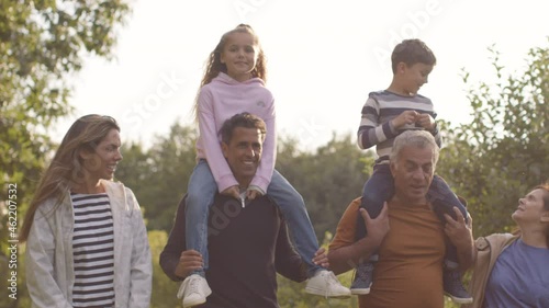 Tracking Shot of Children Sitting On Their Parents and Grandparents Shoulders 02