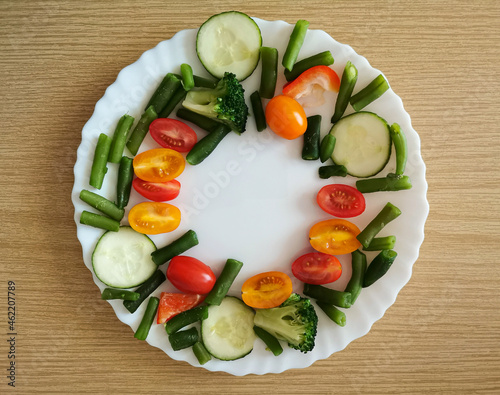 фотографія Fresh Organic Vegetables on wooden Table Around White Plate with copy space for your text