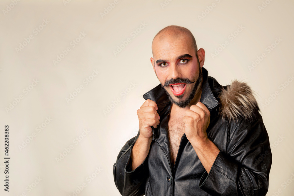 Male person with eye make-up looks at the camera while opening his mouth in surprise. Man with leather jacket and feathers Male person with eye make-up looks at the camera while opening his mouth in surprise. Man with leather jacket and feathers