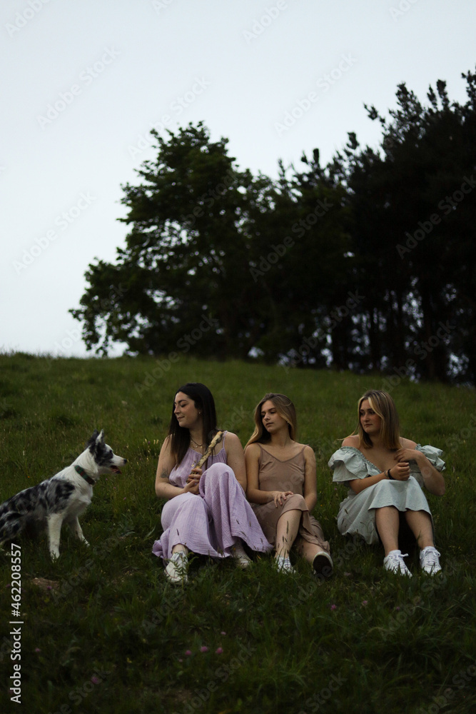 Obraz premium girlfriends smiling in nature in colorful dresses during spring
