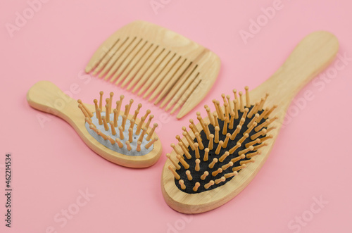 Wooden hairbrushes on a pink background. Hair care with natural accessories