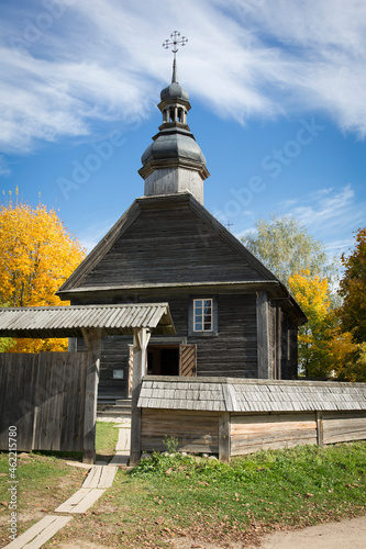 Autumn landscape. Yellow foliage on the trees and a rustic wooden church.