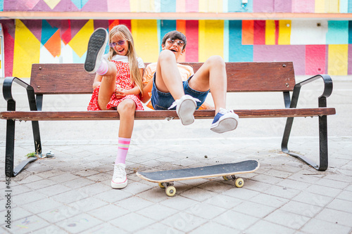 Playful friends sitting on bench photo