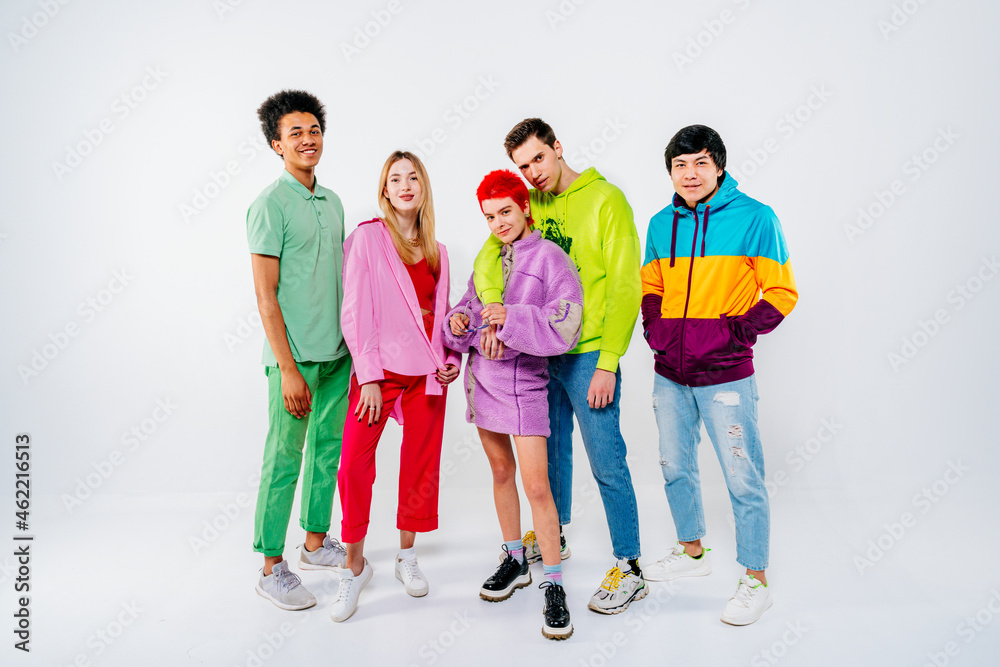 Smiling young men and women in colorful clothes standing on white background Smiling young men and women in colorful clothes standing on white background