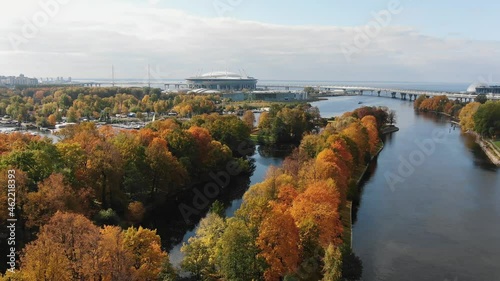 Aerial view of the autumn park and the Zenit Arena sports stadium in St. Petersburg and Krestovsky island with a pier and yachts all-sunny day. Bright colors of the autumn city park. photo