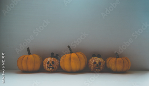 Halloween food background containing orange pumpkins and tangerines