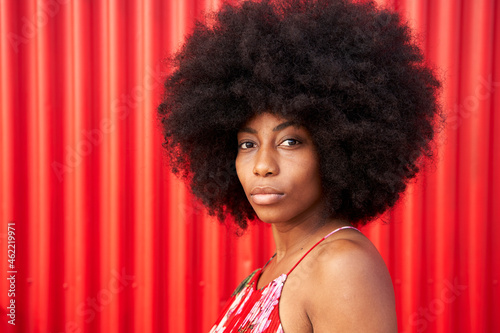 Afro young woman by red corrugated wall photo