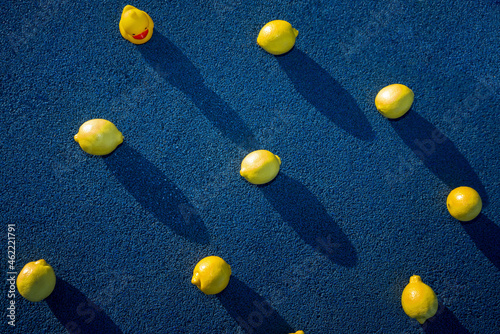 Lemons with yellow rubber duck on blue surface during sunny day photo