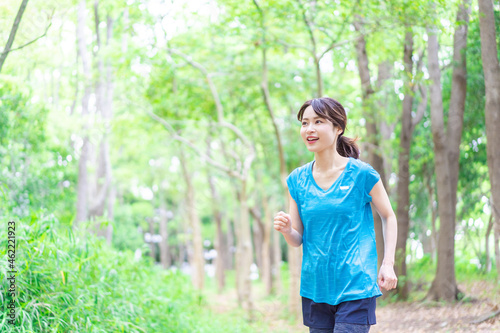 自然の中でランニングをする若い女性