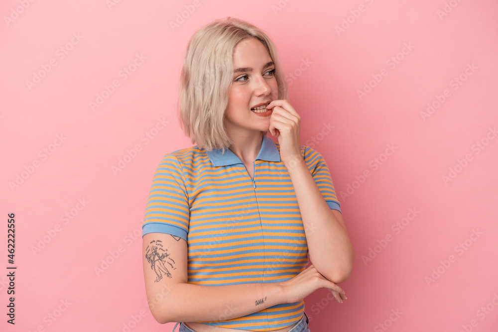Young caucasian woman isolated on pink background relaxed thinking about something looking at a copy space. Young caucasian woman isolated on pink background relaxed thinking about something looking at a copy space.