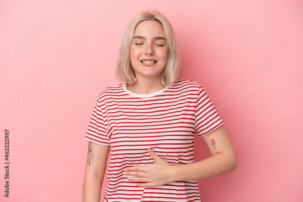 Young caucasian woman isolated on pink background touches tummy, smiles gently, eating and satisfaction concept. Young caucasian woman isolated on pink background touches tummy, smiles gently, eating and satisfaction concept.